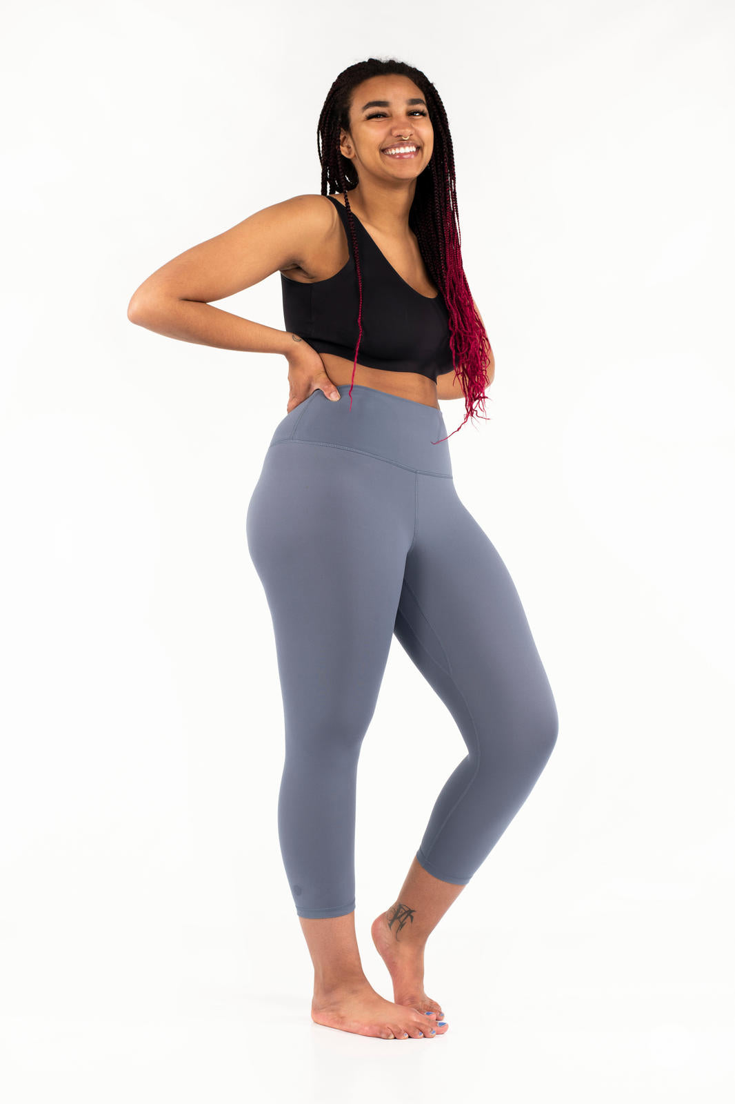 Smiling model wearing gray Free Motion Crops by Athleisure SweetLegs standing barefoot in side pose