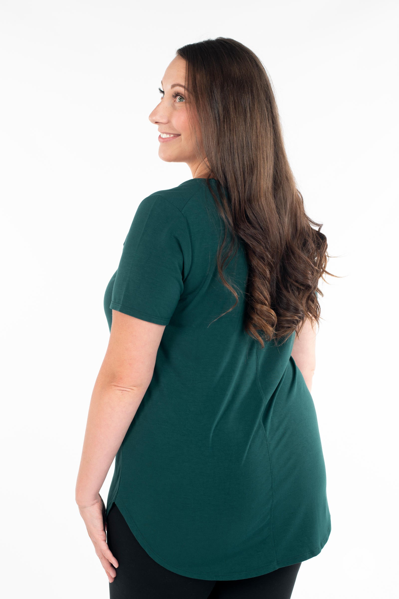 Woman wearing dark green Classic Tee by SweetLegs Canada showing back with short sleeves and curved hem