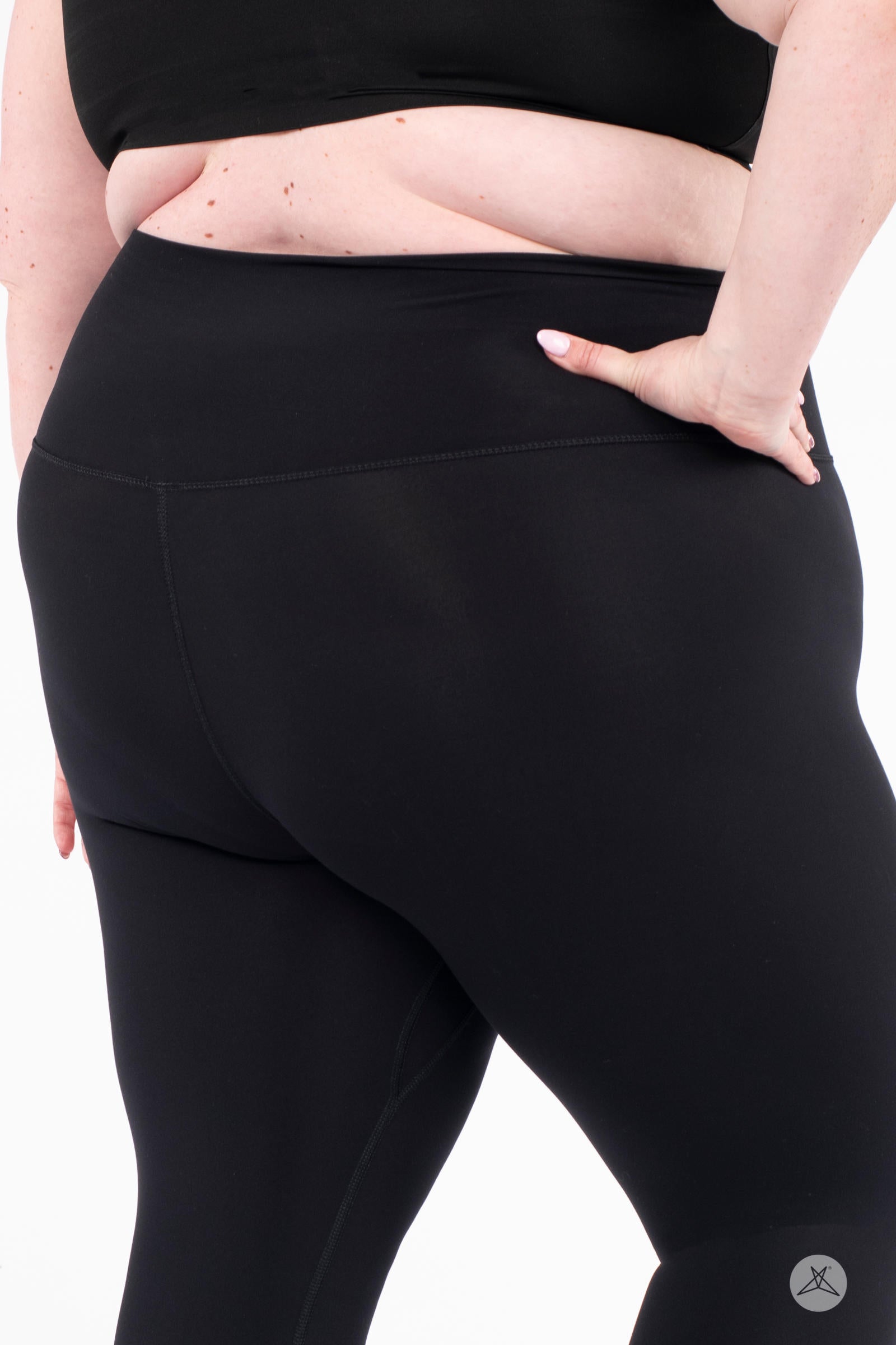 Close-up rear view of plus-size model wearing black Free Motion Crops by Athleisure SweetLegs collection