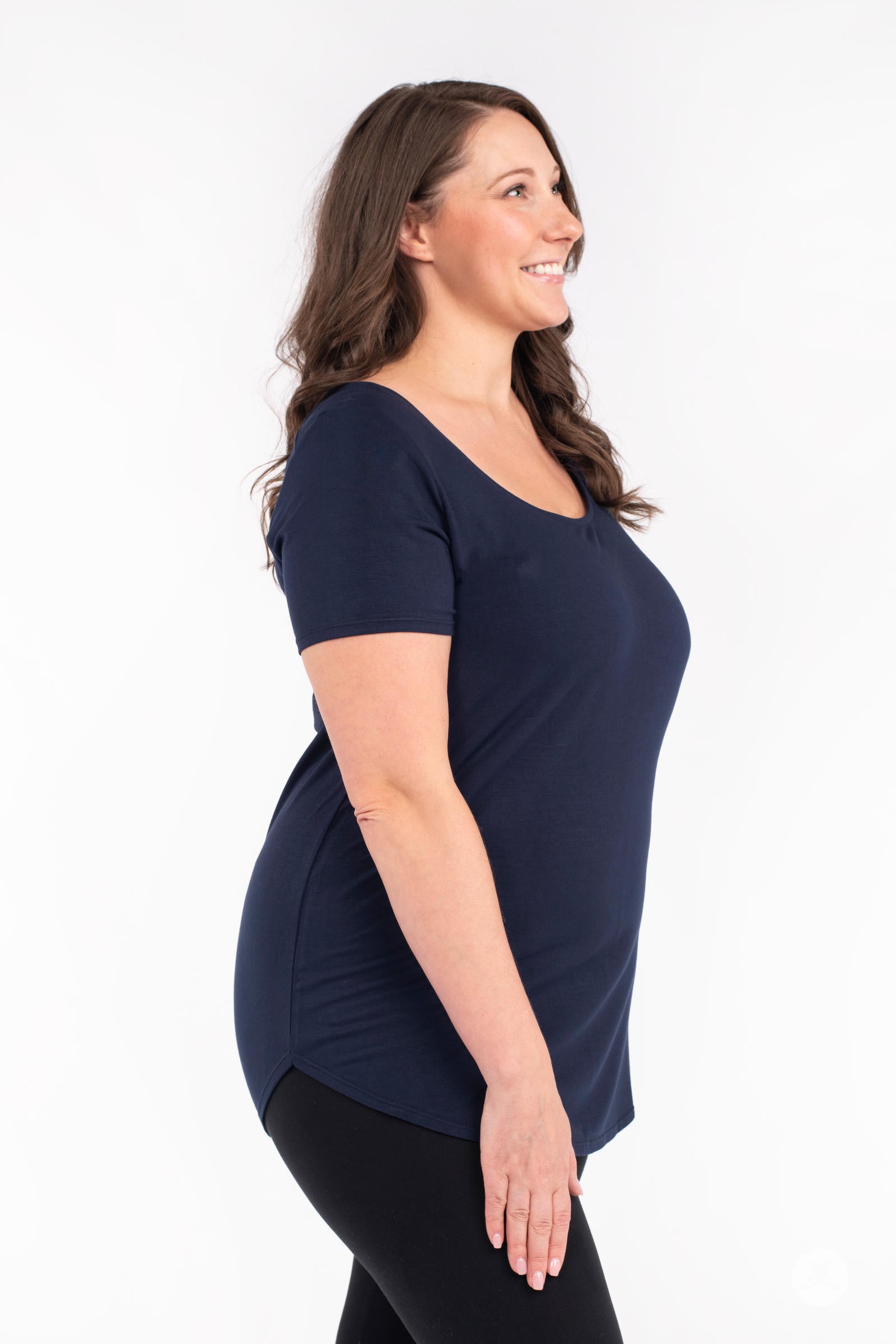 Smiling woman wearing navy Classic Tee by SweetLegs Canada with scoop neck and fitted silhouette side view