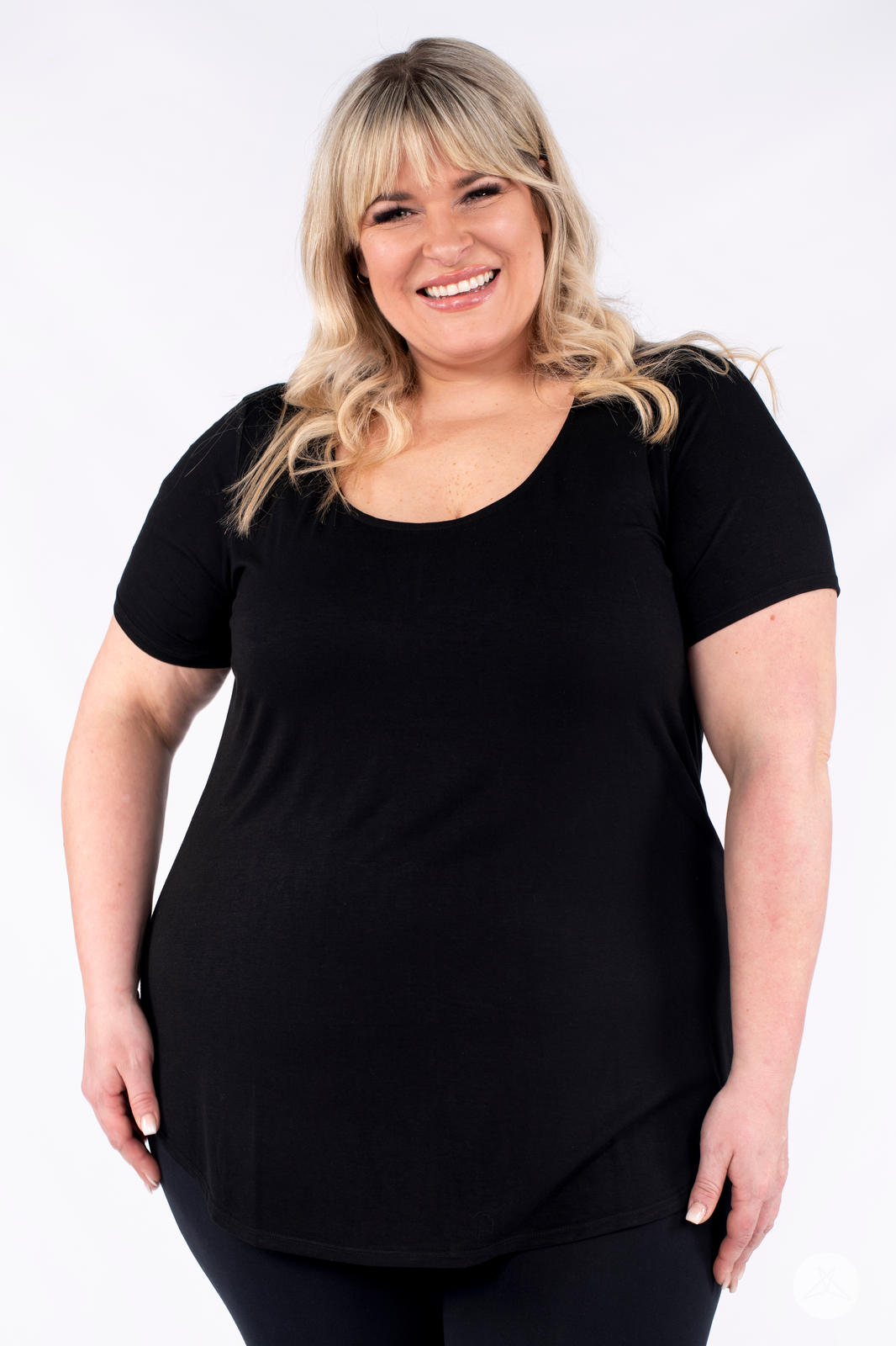 Plus size woman smiling wearing black Classic Tee by SweetLegs Canada with scoop neck and relaxed fit front view