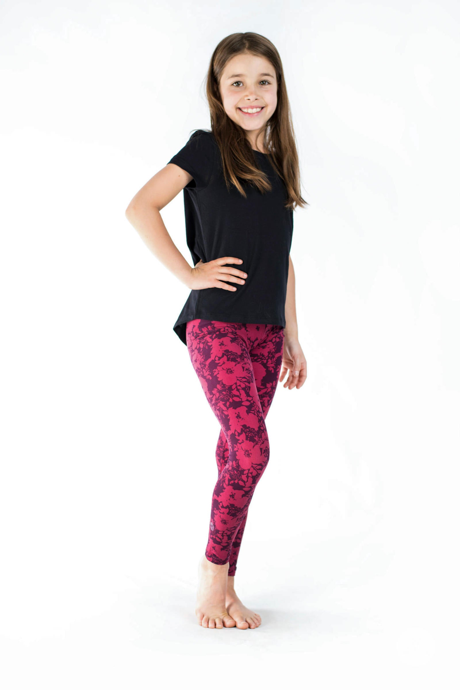 Young girl wearing SweetLegs Summer Blush Kids leggings featuring two-toned merlot and cherry floral pattern