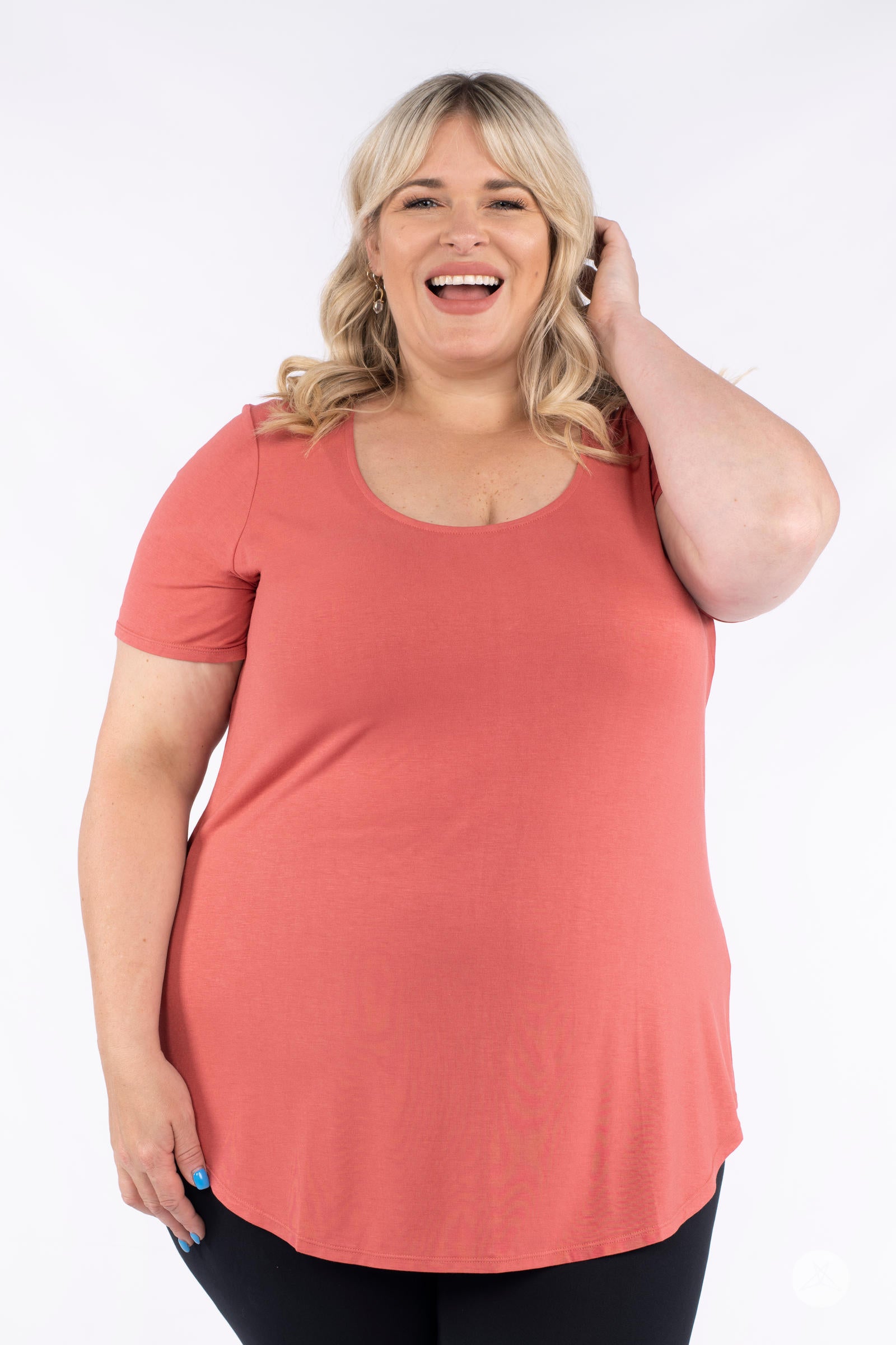 Plus size woman smiling wearing coral Classic Tee by SweetLegs Canada with scoop neck and relaxed fit front view