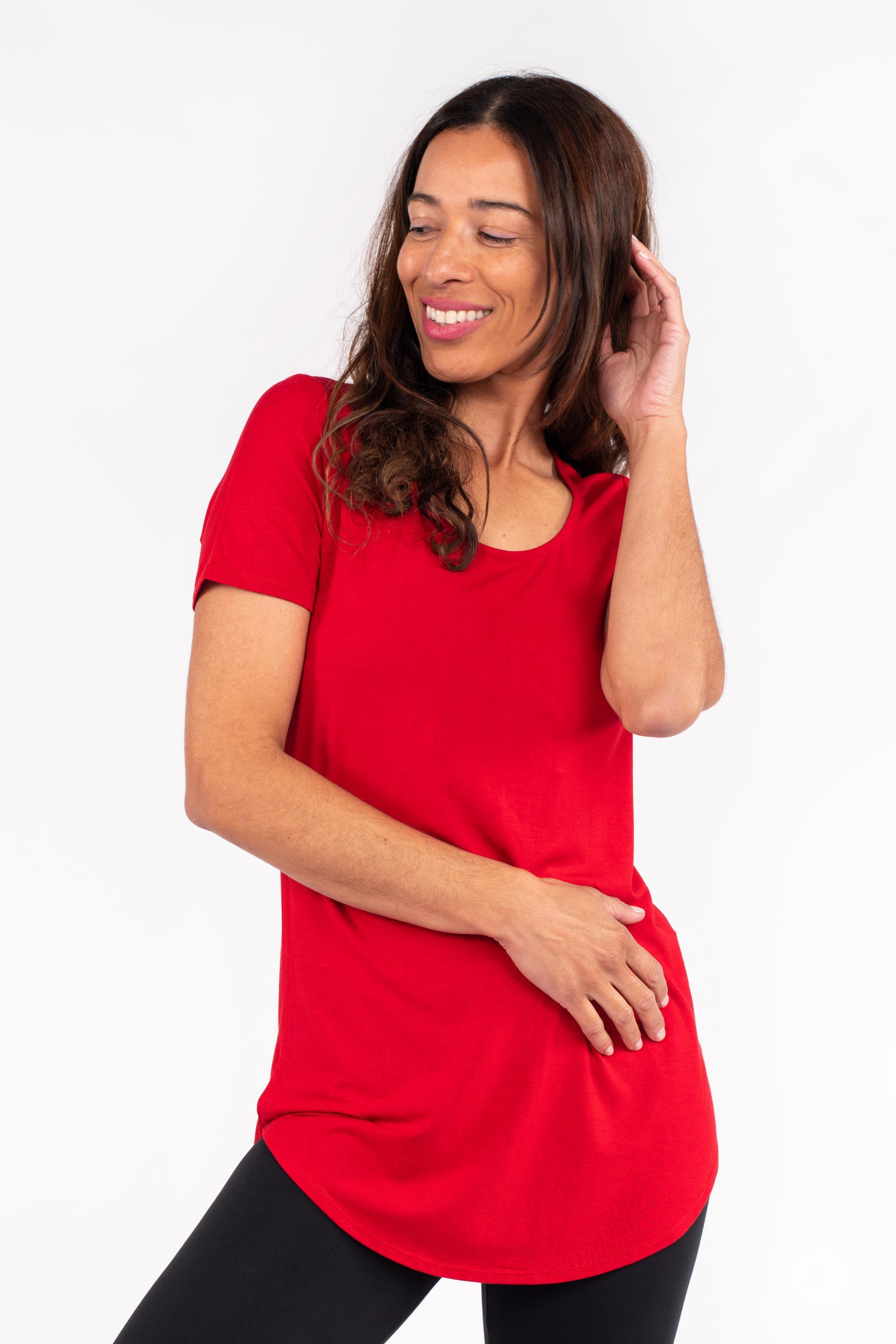 Model wearing red Classic Tee by SweetLegs Canada with scoop neckline and short sleeves, posing with hand near face