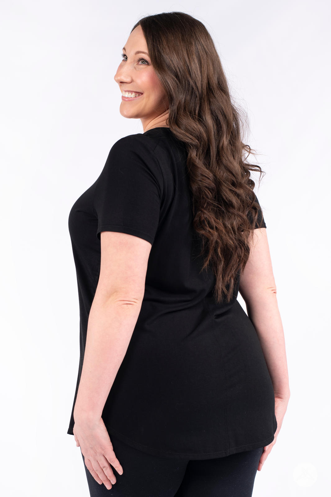 Woman smiling wearing black Classic Tee by SweetLegs Canada with short sleeves and relaxed fit back view
