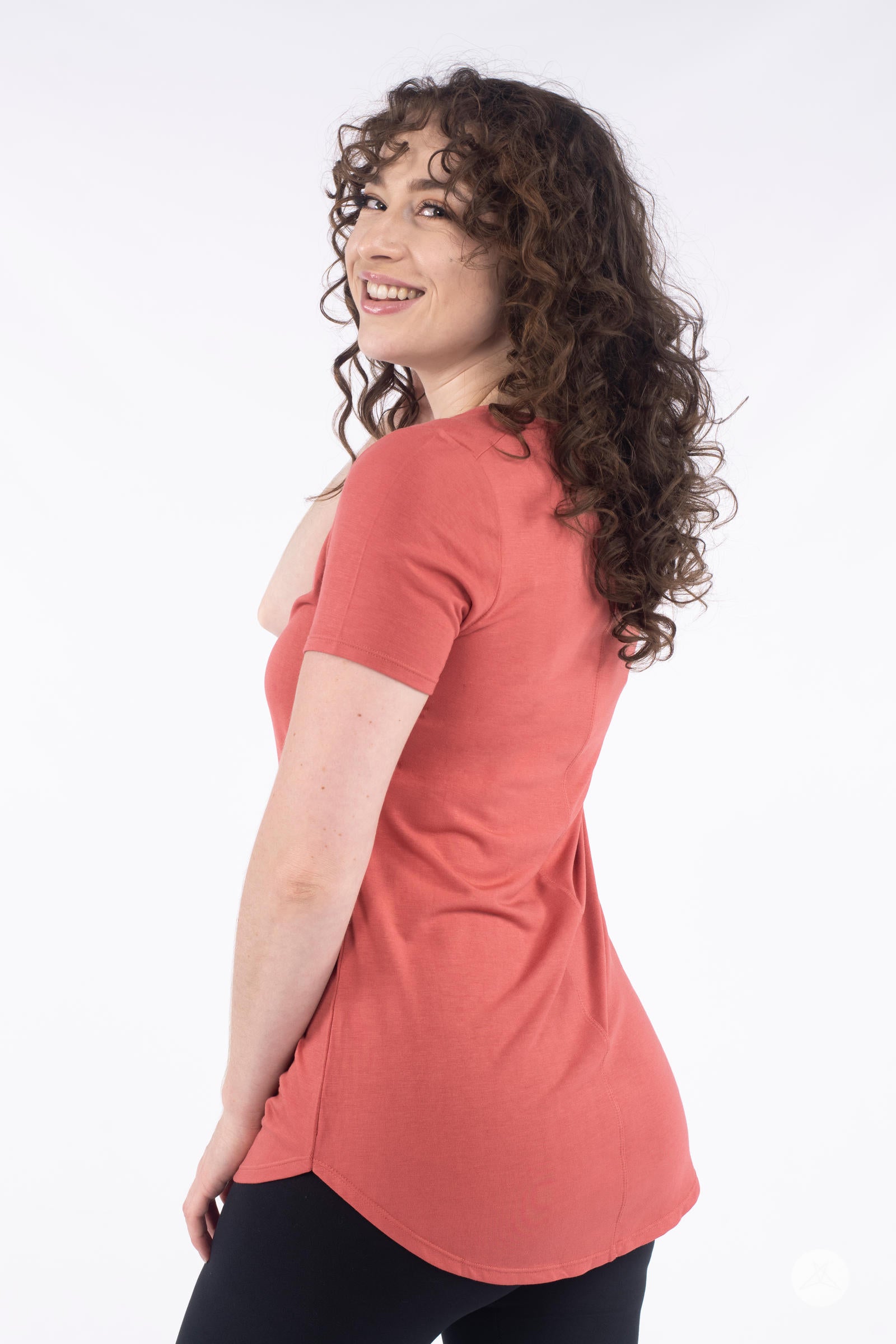 Woman smiling wearing rust Classic Tee by SweetLegs Canada with short sleeves and high to low hem side angle