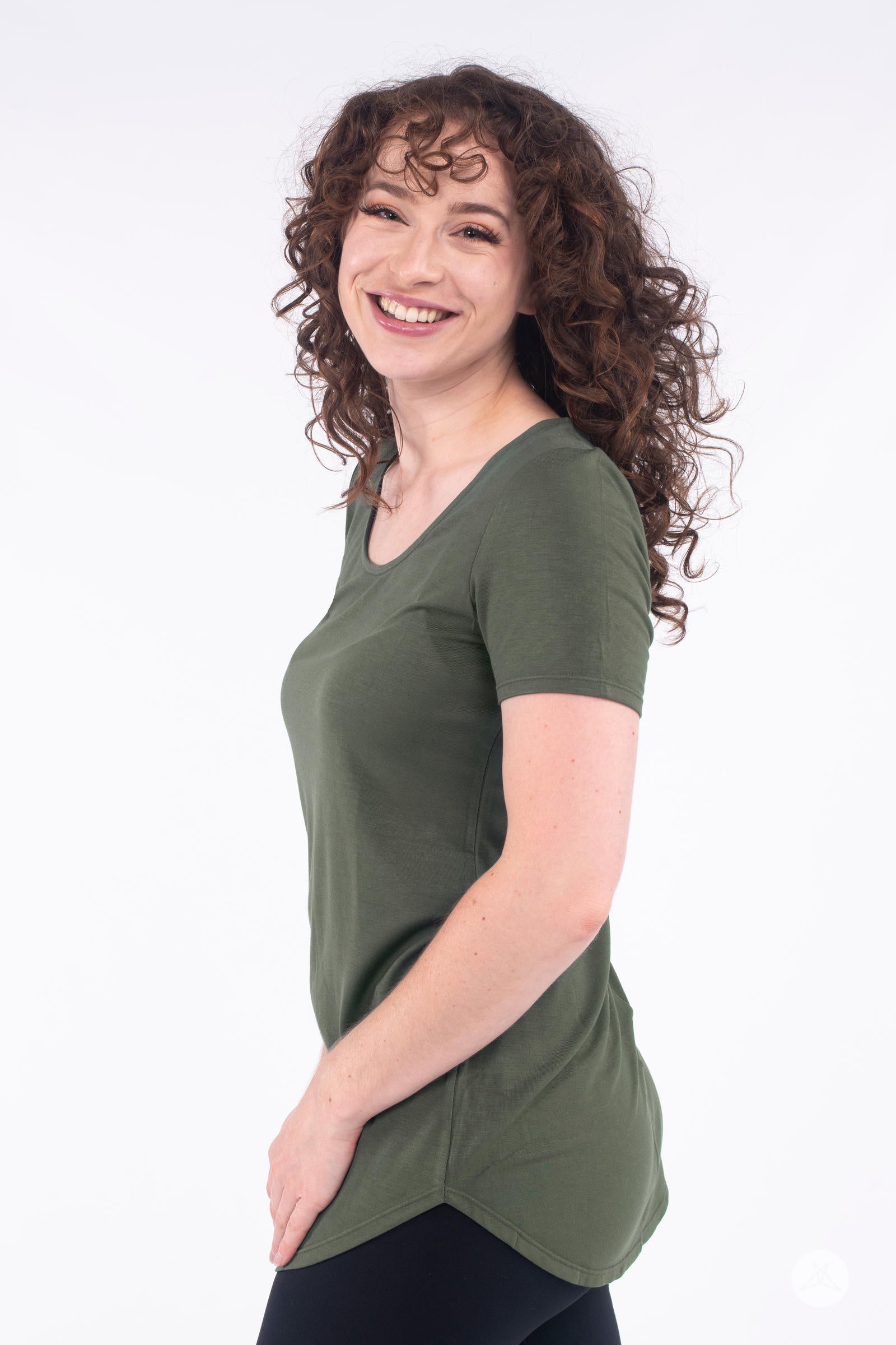 Smiling model in side view wearing SweetLegs Canada Classic Tee in olive with short sleeves and scoop neckline