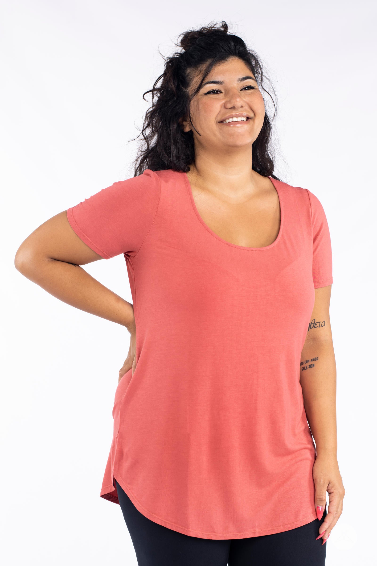 Smiling woman wearing coral Classic Tee by SweetLegs Canada with scoop neck and relaxed fit front view