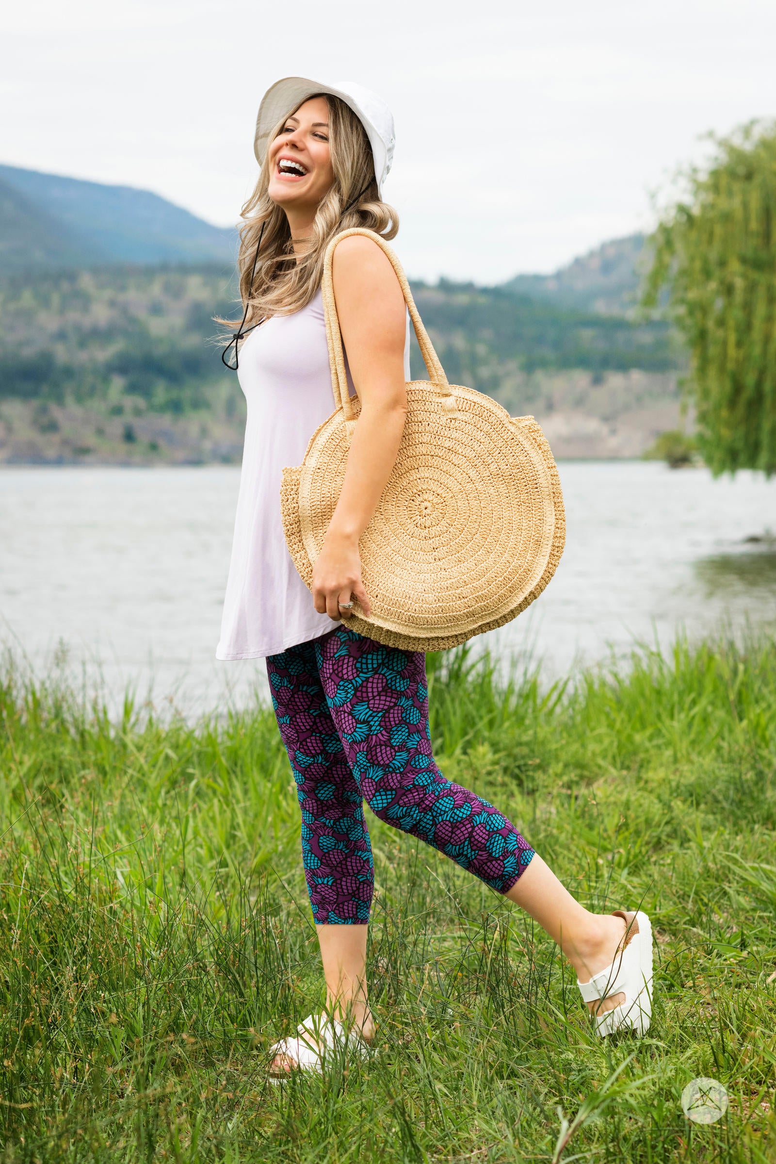 Woman outdoors wearing SweetLegs Razzle Dazzle Crops with vibrant purple and teal pineapple pattern cropped leggings