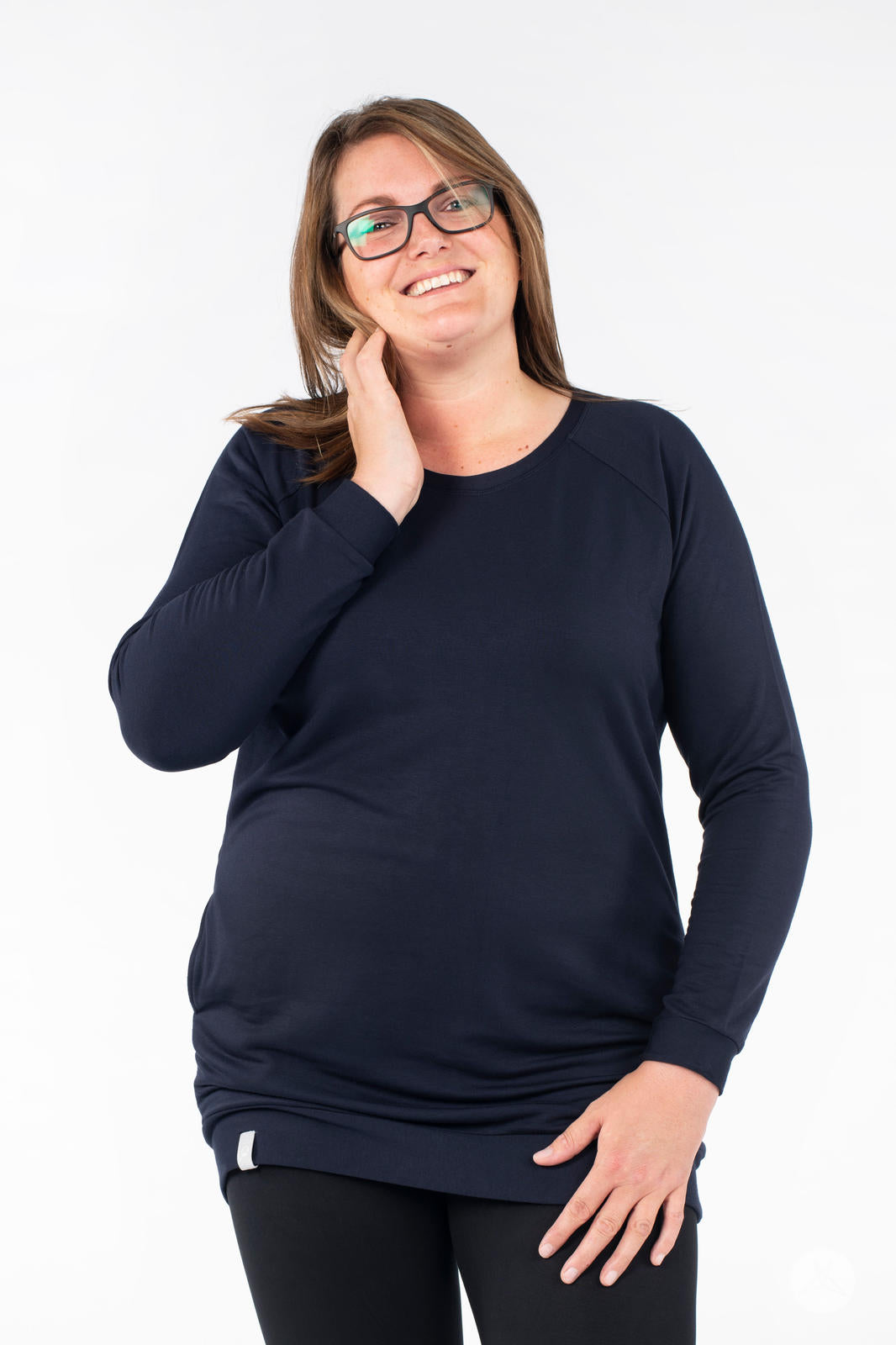 Smiling model wearing SweetLegs Canada Everyday Raglan Pullover in navy touching face with relaxed pose