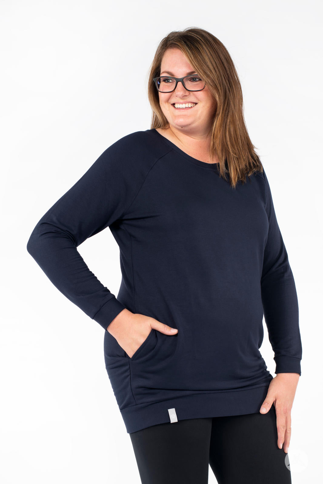 Plus-size model smiling wearing SweetLegs Canada Everyday Raglan Pullover in navy with hand in pocket and side pose