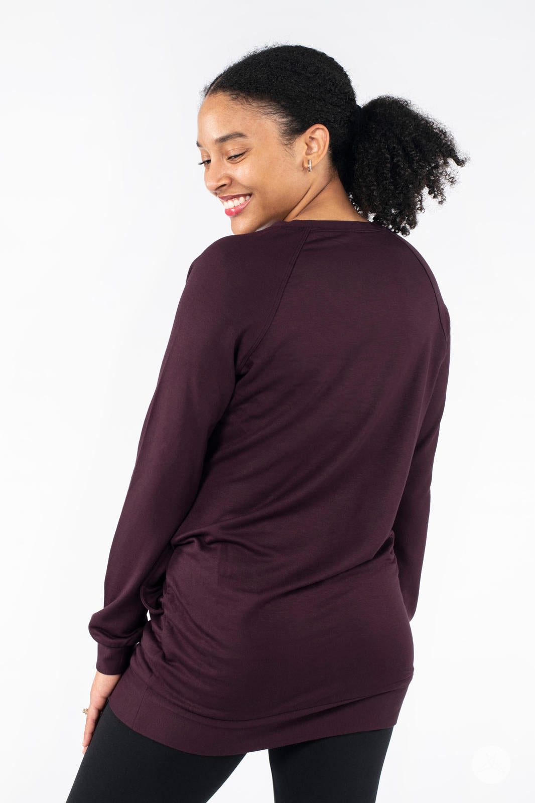 Rear view of SweetLegs Canada Everyday Raglan Pullover in deep plum worn by smiling model looking over shoulder