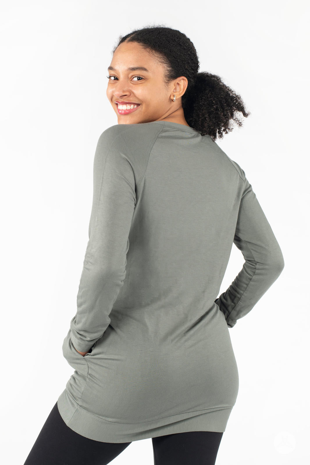 Smiling model showcasing the back of SweetLegs Canada Everyday Raglan Pullover in muted green with hands on hips