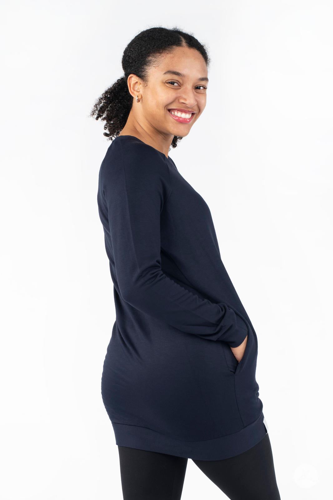 Smiling model posing in SweetLegs Canada Everyday Raglan Pullover in navy with hands resting in pockets