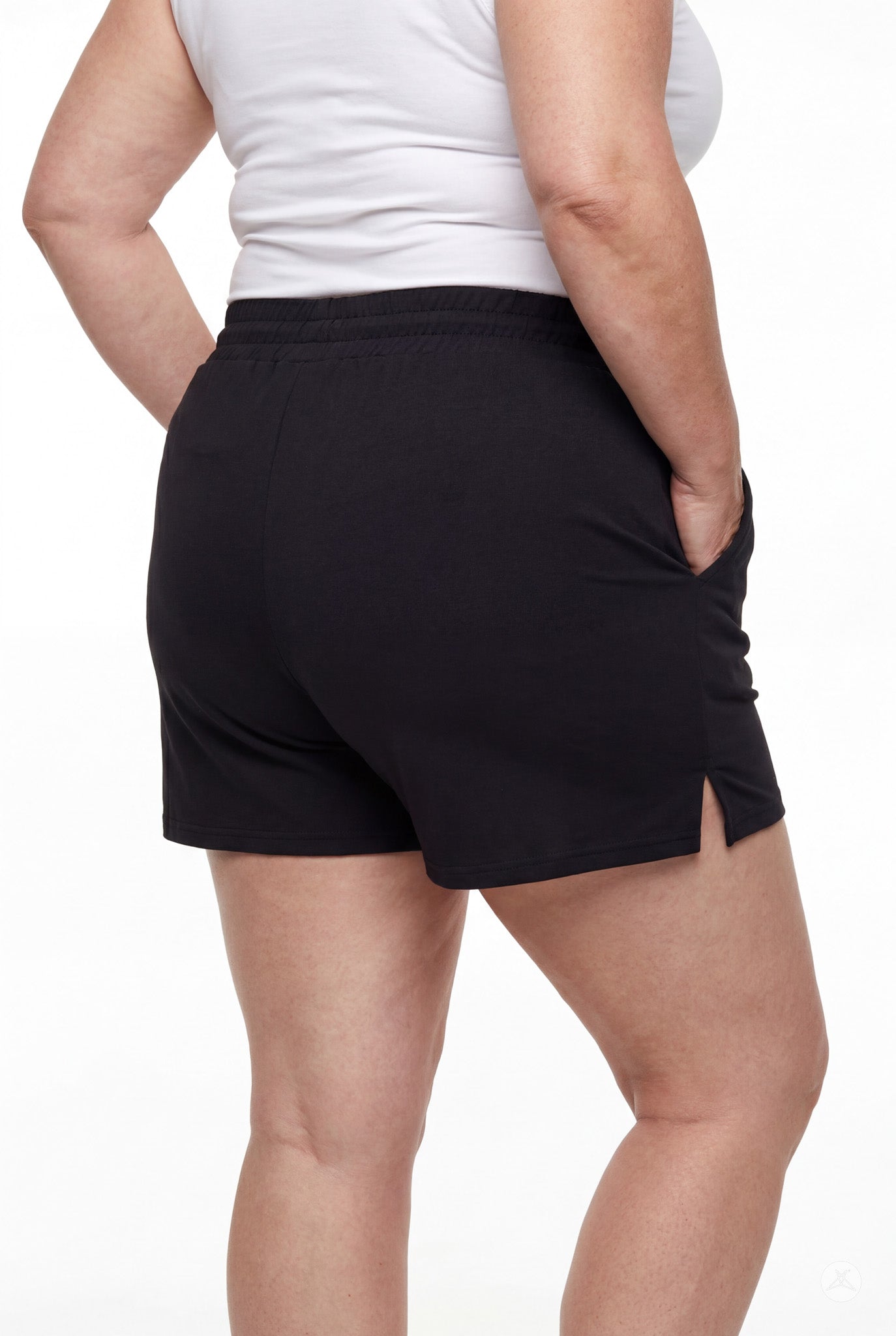 Rear view of person wearing black Lounge Shorts by SweetLegs with side slits and elastic waistband with hands in pockets