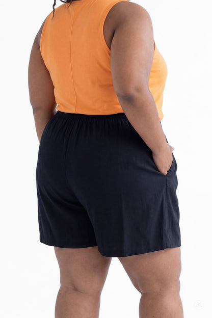 Plus size woman wearing SweetLegs Breeze Shorts in black with elastic waistband and side pockets, paired with orange top