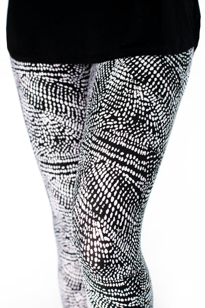 Close-up of SweetLegs Charmed leggings in black and white abstract dot pattern on model legs