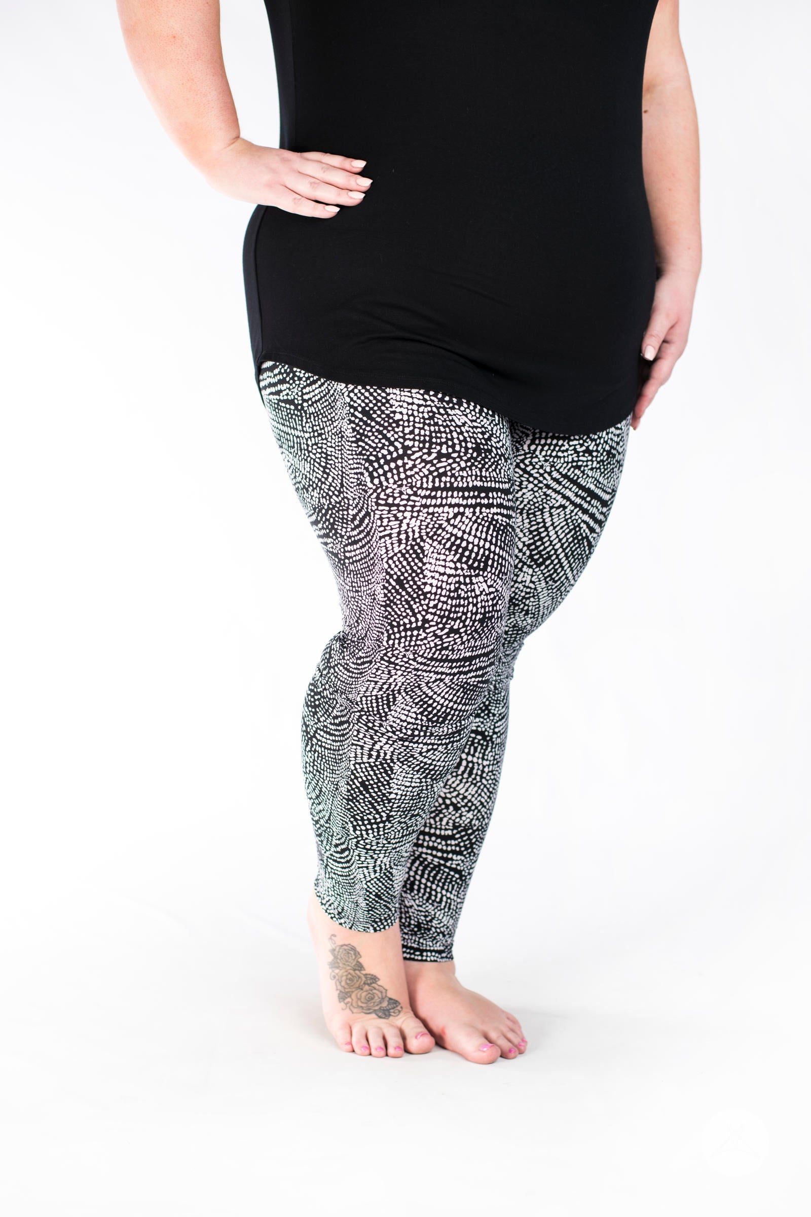 Plus size model wearing SweetLegs Charmed leggings with a textured black and white abstract snakeskin print