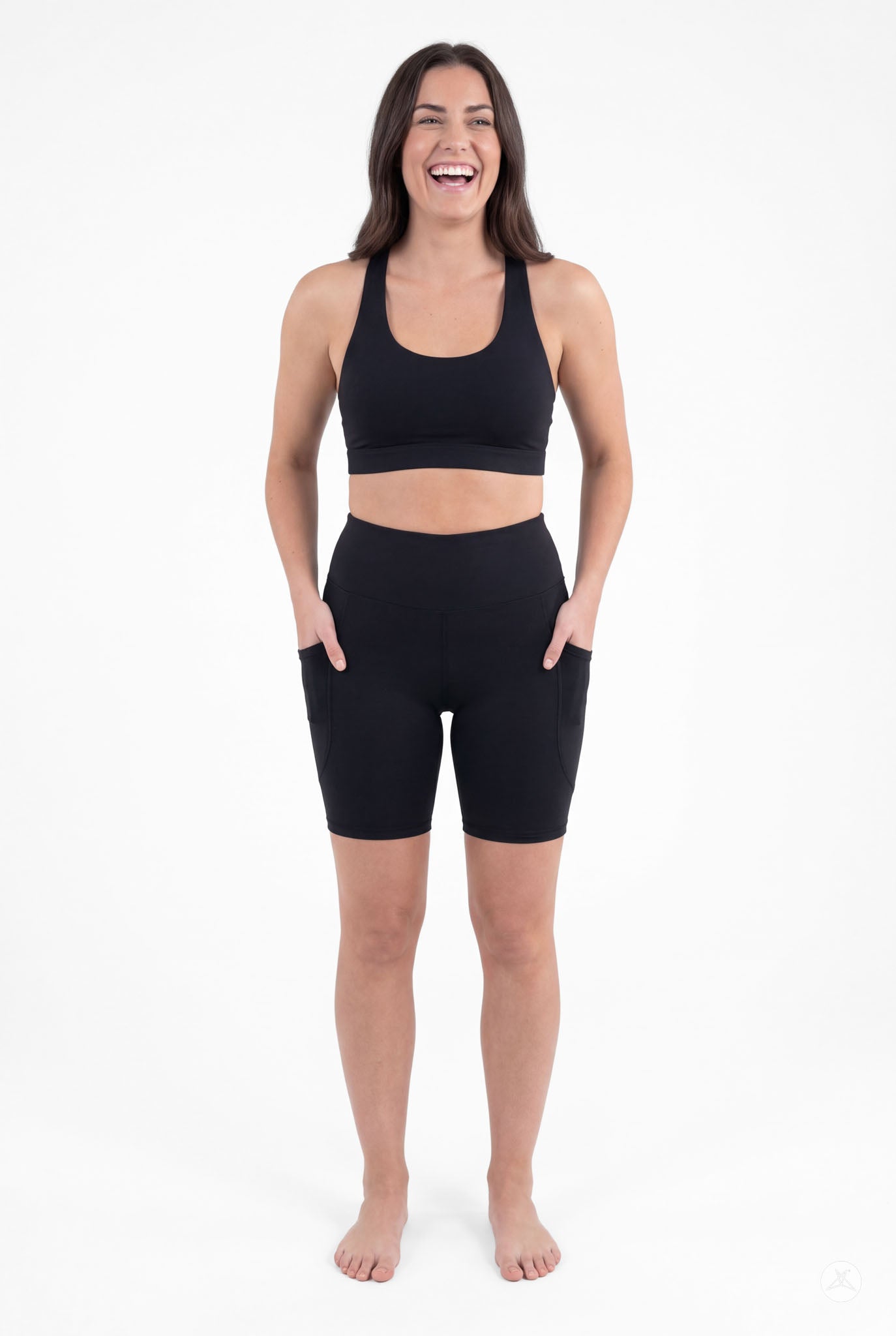 Smiling woman wearing SweetLegs Black High-Waisted Pocket Biker Shorts with hands in side pockets front view
