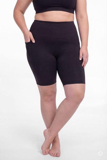 Plus size model wearing SweetLegs Black High-Waisted Pocket Biker Shorts with hand resting in side pocket front view