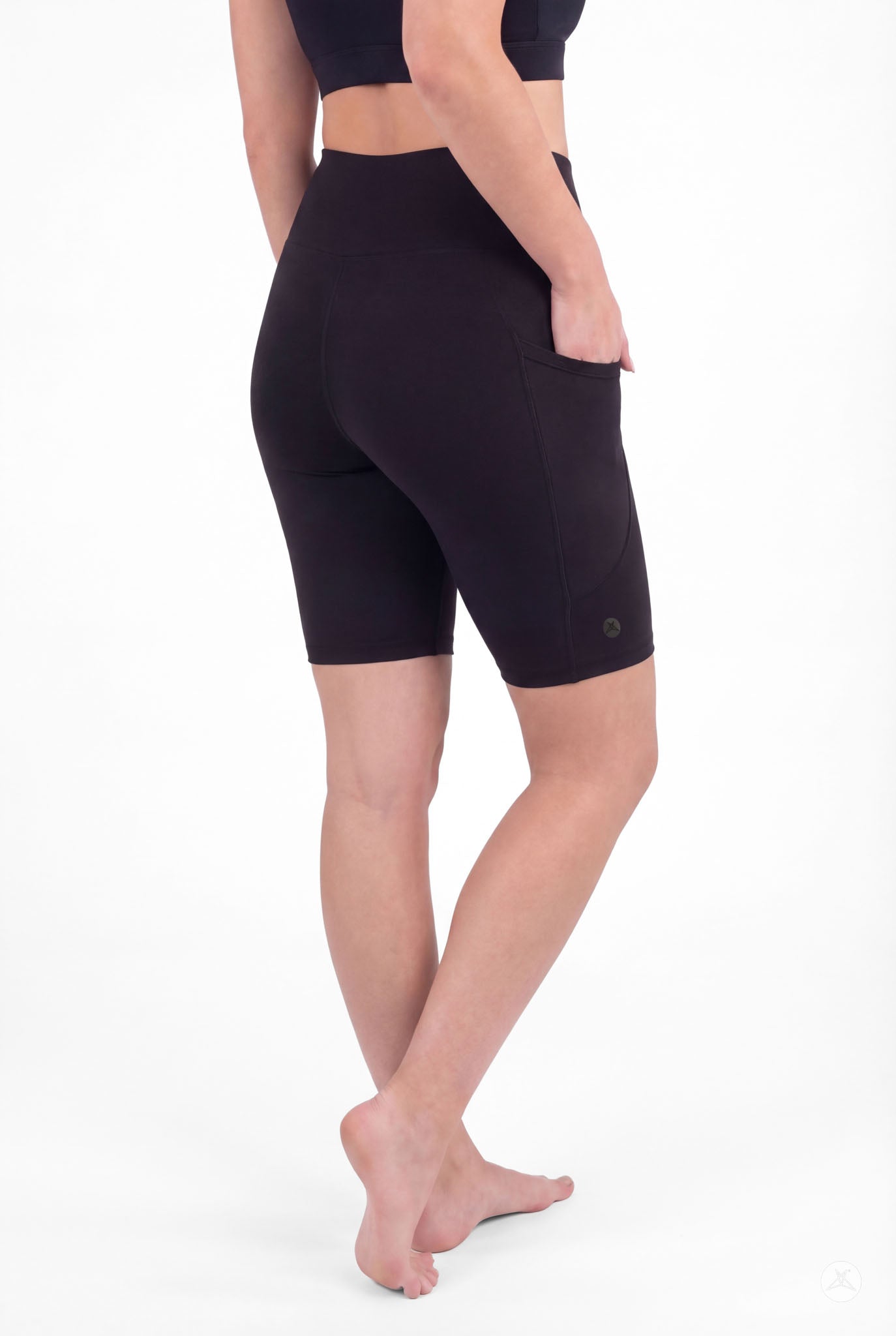 Back view of model wearing SweetLegs Black High-Waisted Pocket Biker Shorts with hand in side pocket