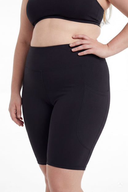 Curvy model wearing SweetLegs Black High-Waisted Pocket Biker Shorts with hand on hip, front view showing pocket design