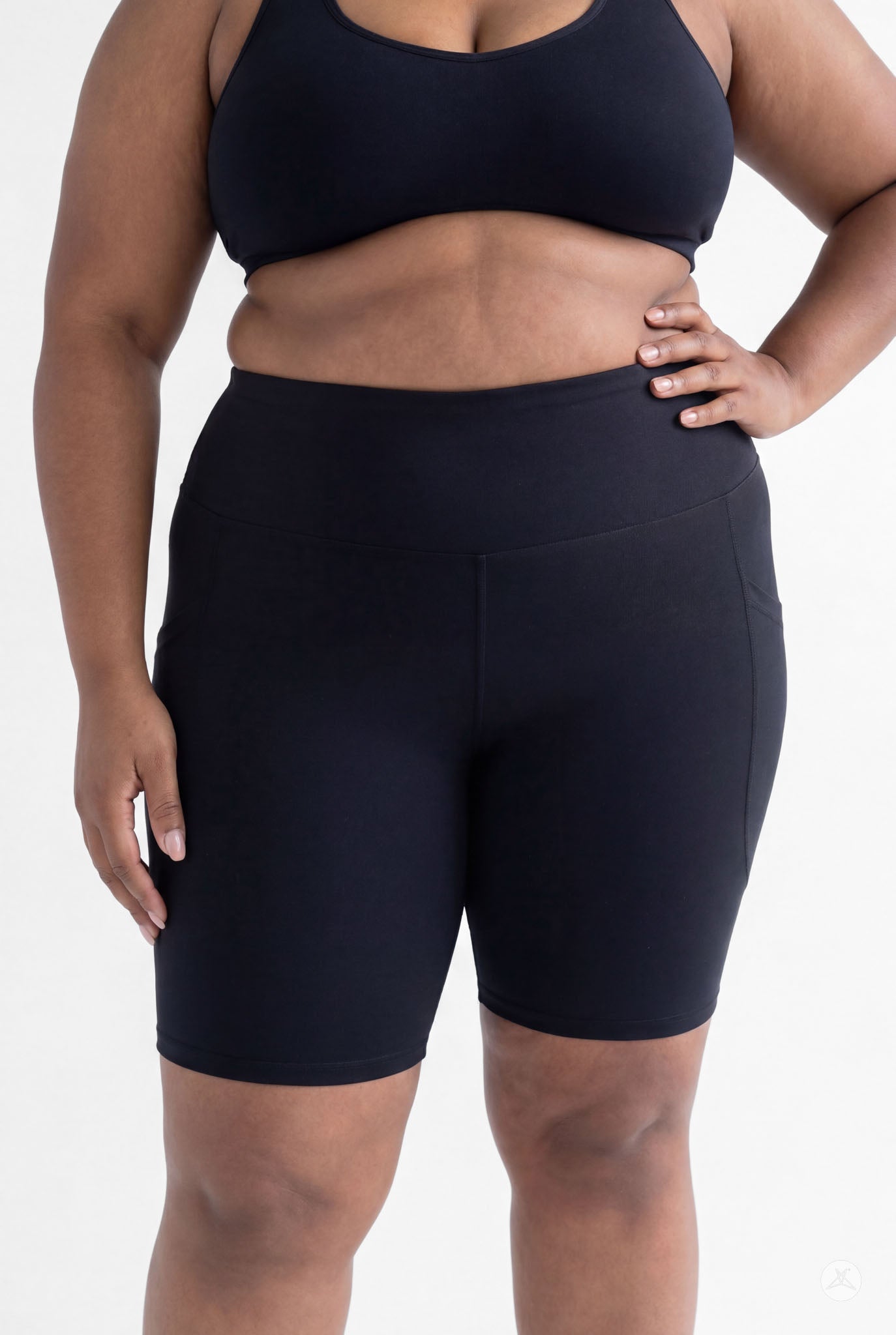Curvy model wearing SweetLegs Black High-Waisted Pocket Biker Shorts with hand resting on hip and side pocket visible