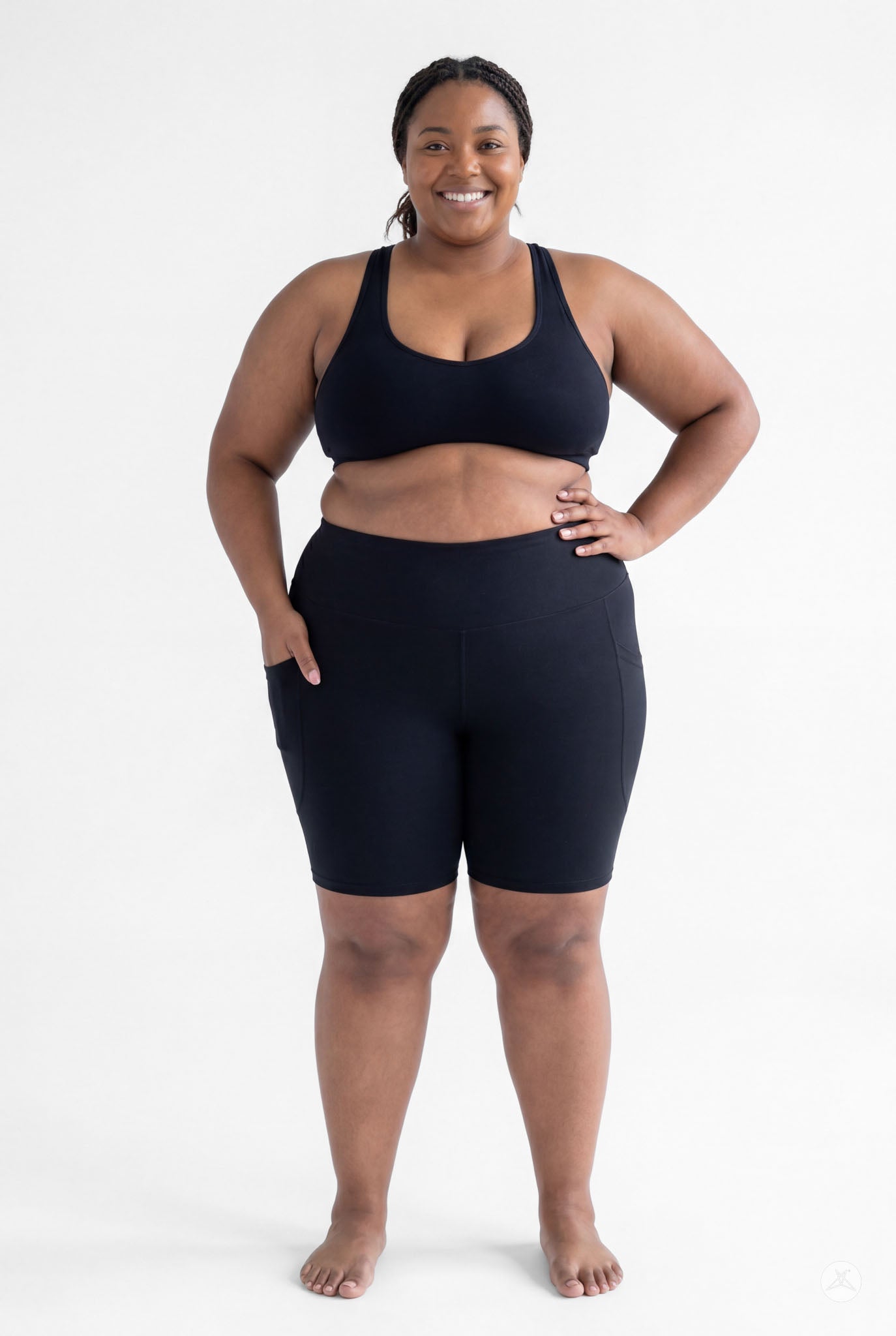 Plus size model smiling wearing SweetLegs Black High-Waisted Pocket Biker Shorts with hand in side pocket front view