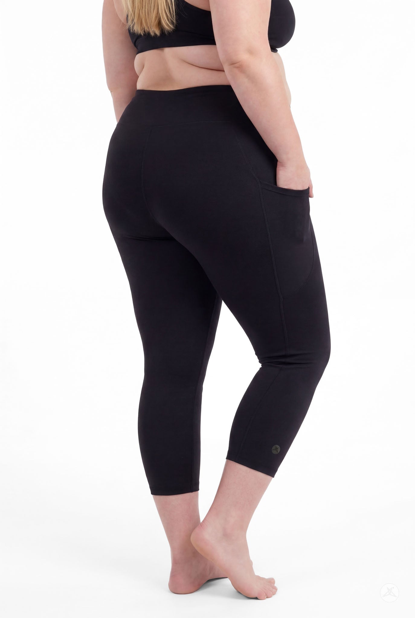Plus size woman barefoot wearing SweetLegs Black High-Waisted Pocket Crops with side pocket detail standing relaxed back view