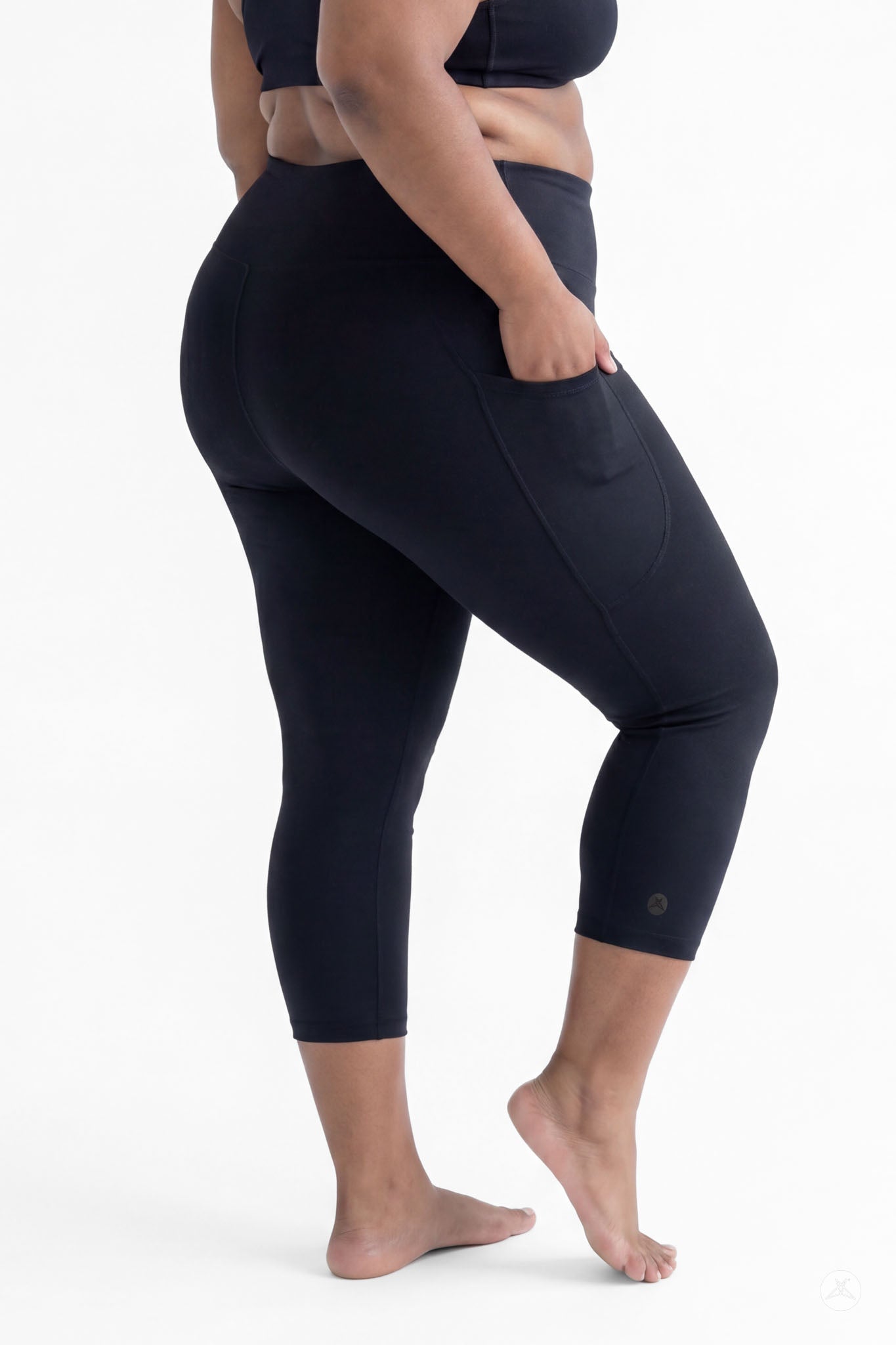 Plus size woman barefoot wearing SweetLegs Black High-Waisted Pocket Crops in relaxed back pose with hand in pocket