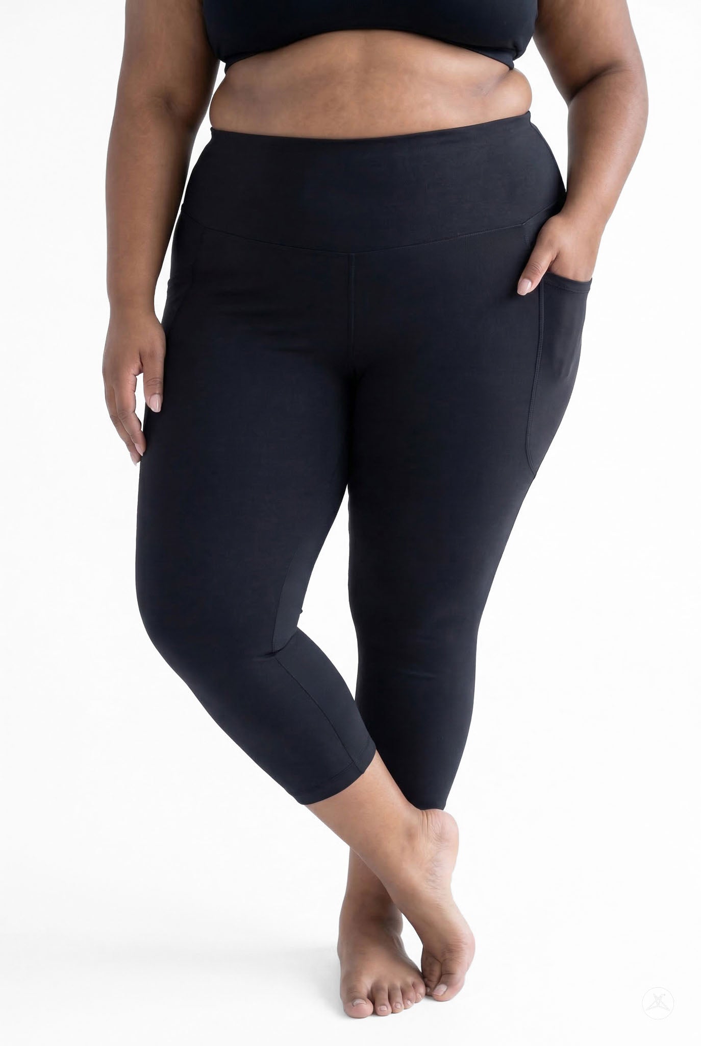 Plus size woman barefoot wearing SweetLegs Black High-Waisted Pocket Crops with hand in side pocket standing front view