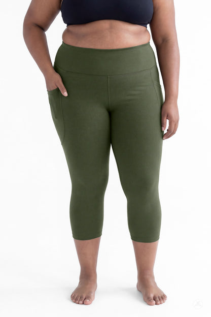 Plus size woman wearing SweetLegs Cedar High-Waisted Pocket Crops in green standing barefoot with hands in pockets