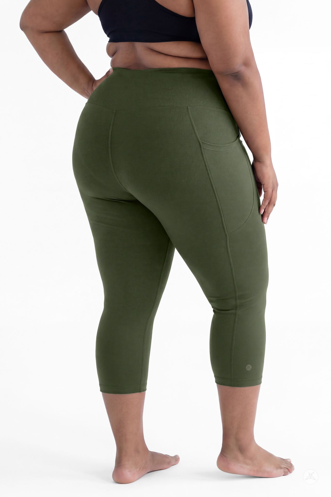Plus size woman barefoot showing back view wearing SweetLegs Cedar High-Waisted Pocket Crops in green leggings