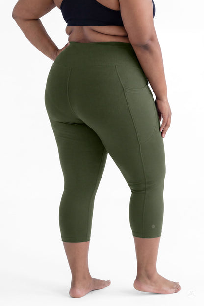 Plus size woman barefoot showing back view wearing SweetLegs Cedar High-Waisted Pocket Crops in green leggings
