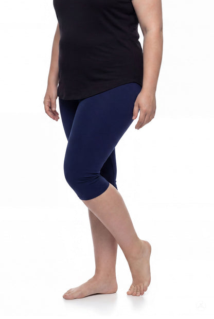 Woman wearing SweetLegs Knee-Length Capri in navy blue paired with black top standing barefoot on white background