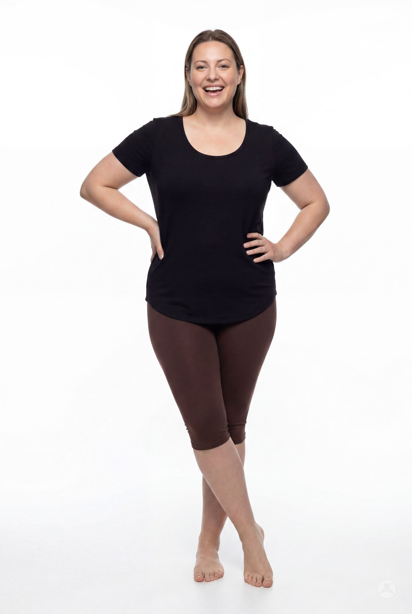 Smiling woman modeling SweetLegs Knee-Length Capri in walnut brown paired with black short sleeve top barefoot