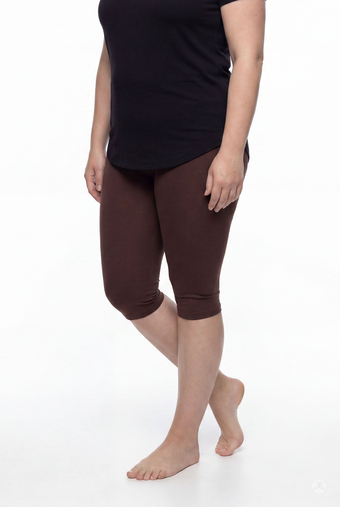 Woman modeling SweetLegs Knee-Length Capri in walnut brown with black top standing barefoot on white background
