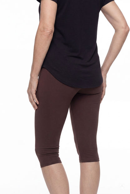 Woman wearing SweetLegs Knee-Length Capri in deep brown with black top shown from back on white background