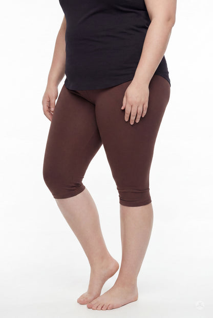Woman wearing SweetLegs Knee-Length Capri in rich brown paired with black top standing barefoot on white background