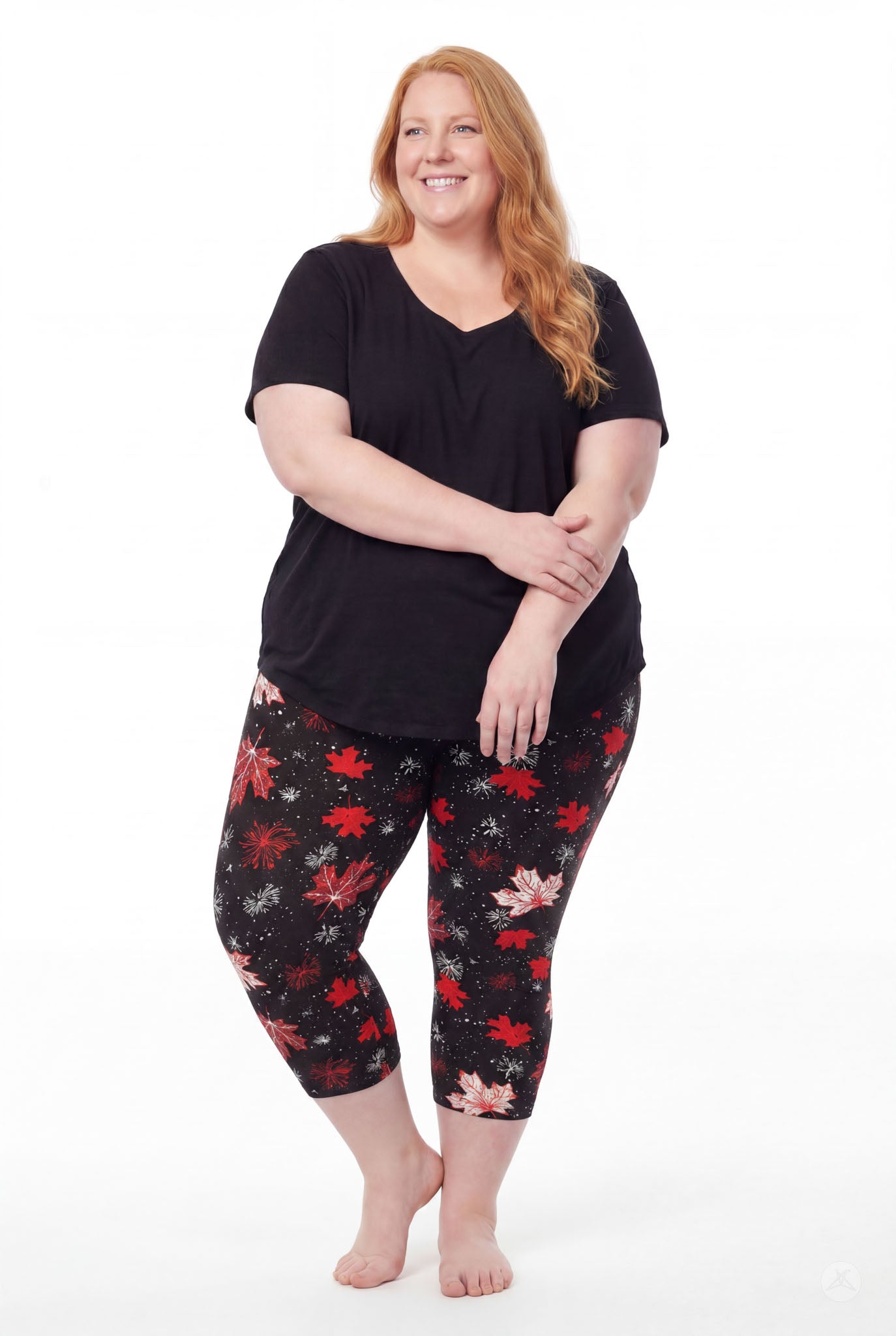 Plus size model wearing SweetLegs Maple Mood Crops with red and white leaf pattern paired with black short sleeve top barefoot