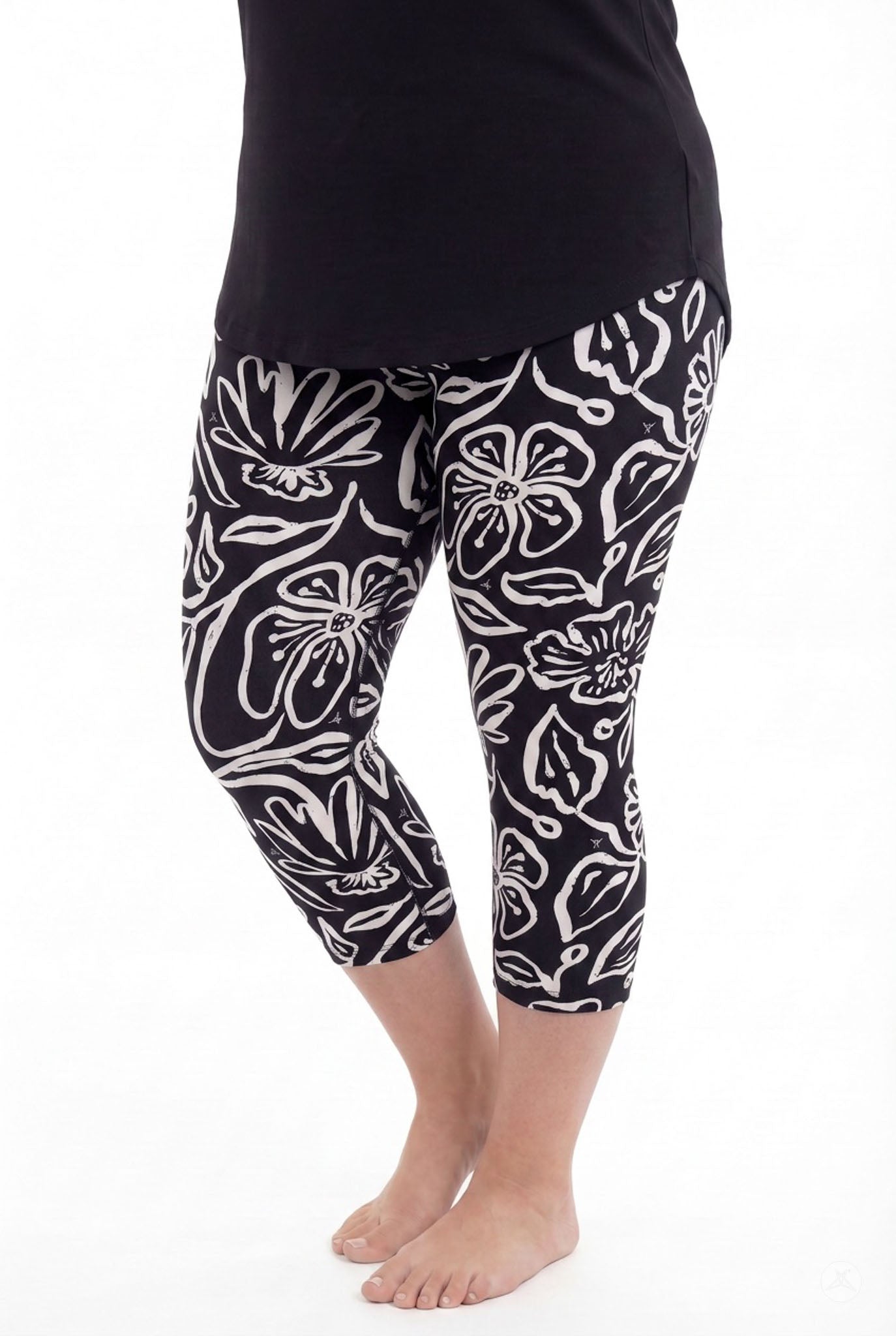 Plus size model wearing SweetLegs Midnight Bloom Crops with black and white floral pattern and black top barefoot