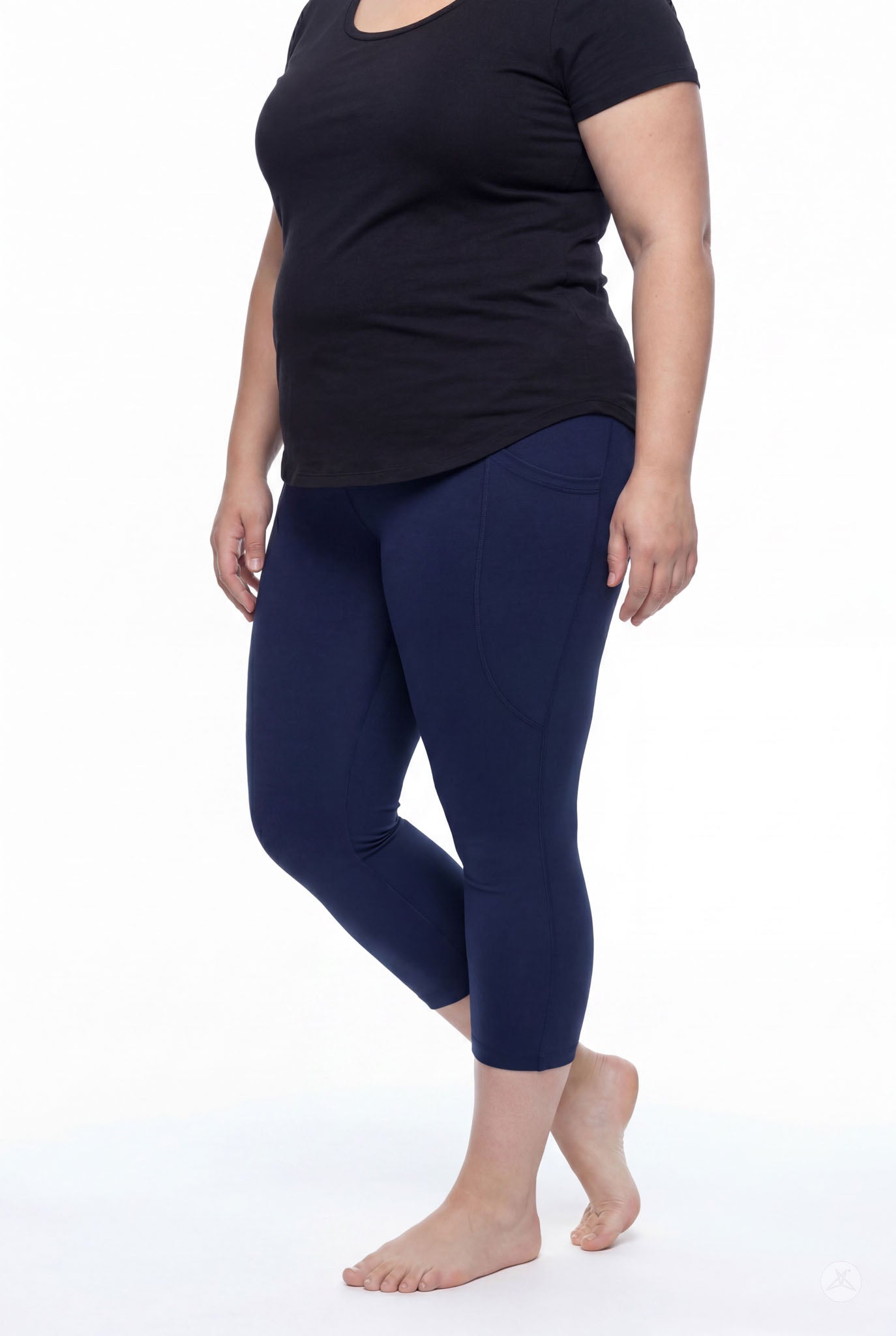Plus size woman barefoot wearing SweetLegs Still Water Pocket Crops navy blue high-waisted leggings side view