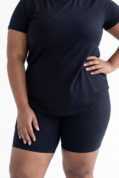 Plus size woman modeling SweetLegs Black Pocket Biker Shorts and black t-shirt with hand on hip front view