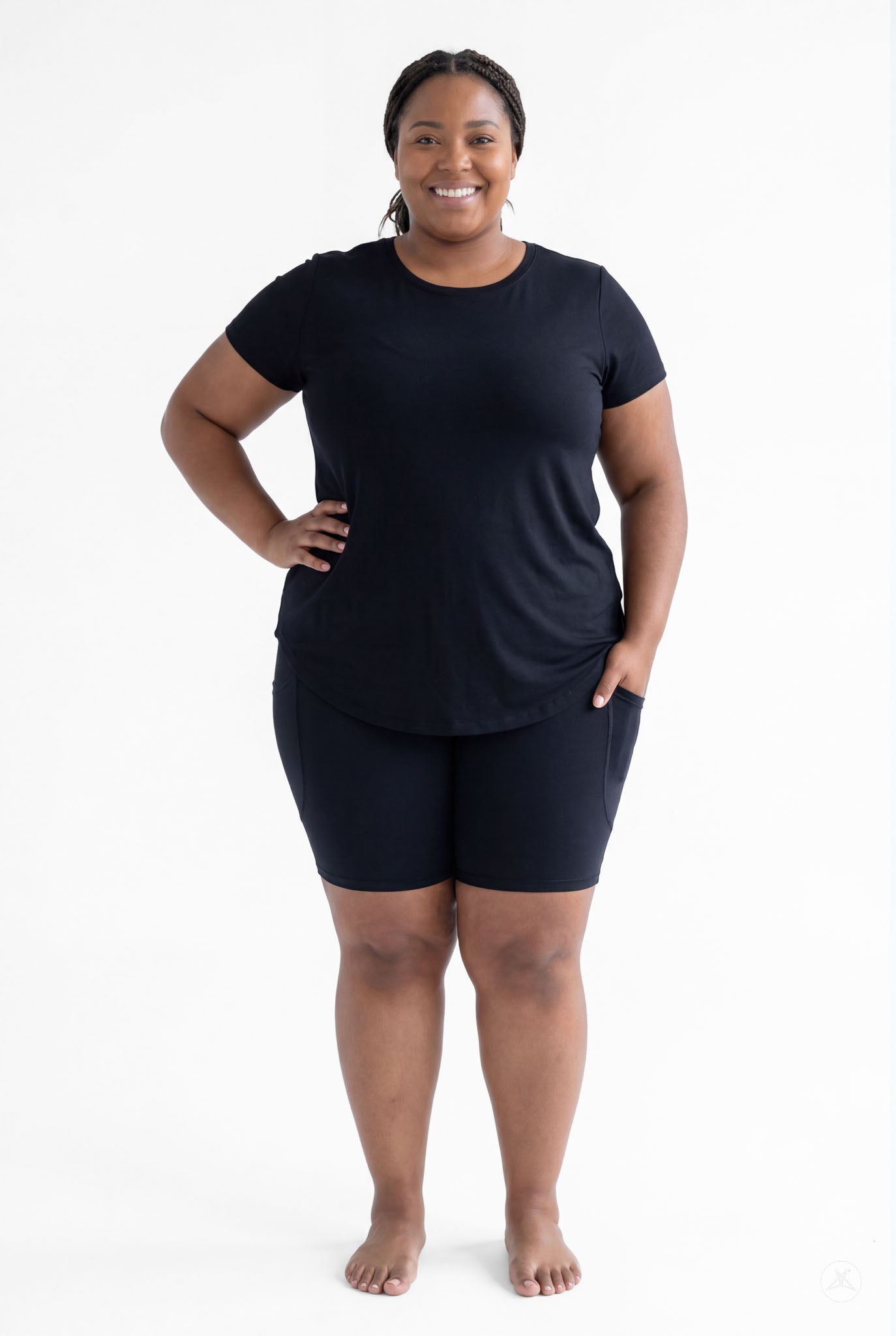 Smiling plus size woman wearing SweetLegs Black Pocket Biker Shorts with black tee standing barefoot front view
