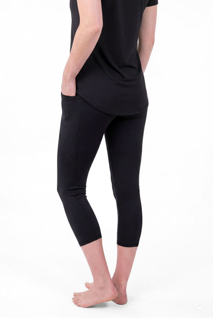 Person wearing SweetLegs Black Pocket Crops with side pockets and black short sleeve top barefoot back view