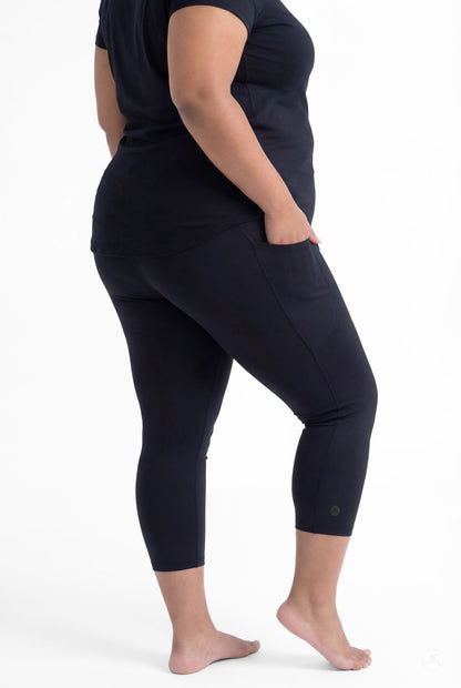 Plus size woman wearing SweetLegs Black Pocket Crops with side pockets and black top barefoot showing back view