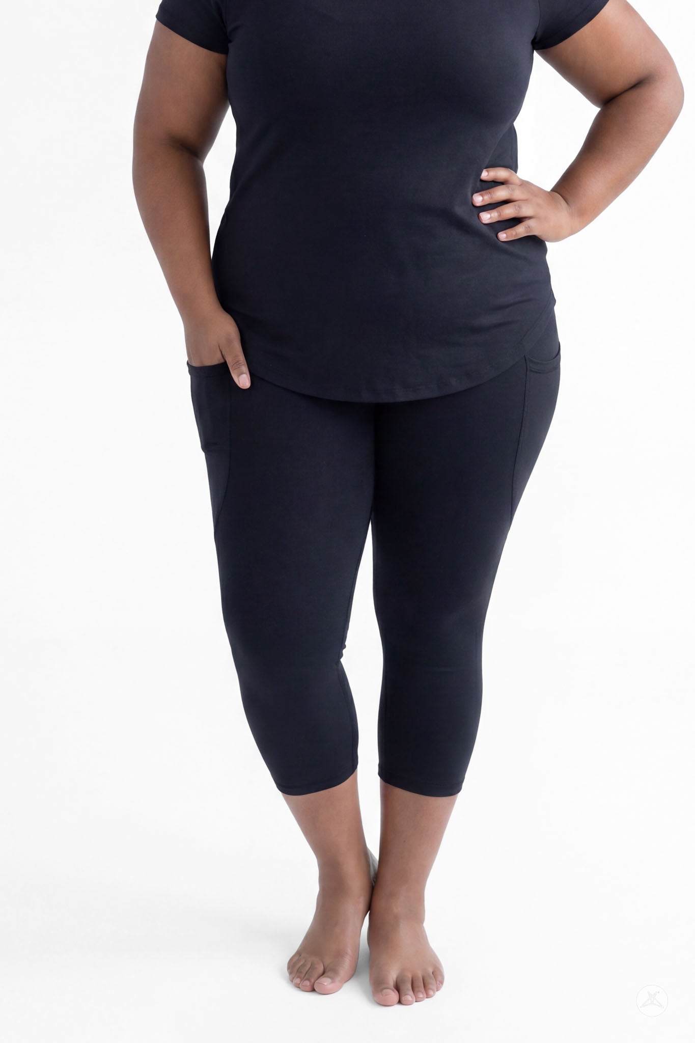 Plus size woman standing barefoot wearing SweetLegs Black Pocket Crops with pockets and black short sleeve top