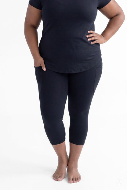 Plus size woman standing barefoot wearing SweetLegs Black Pocket Crops with pockets and black short sleeve top