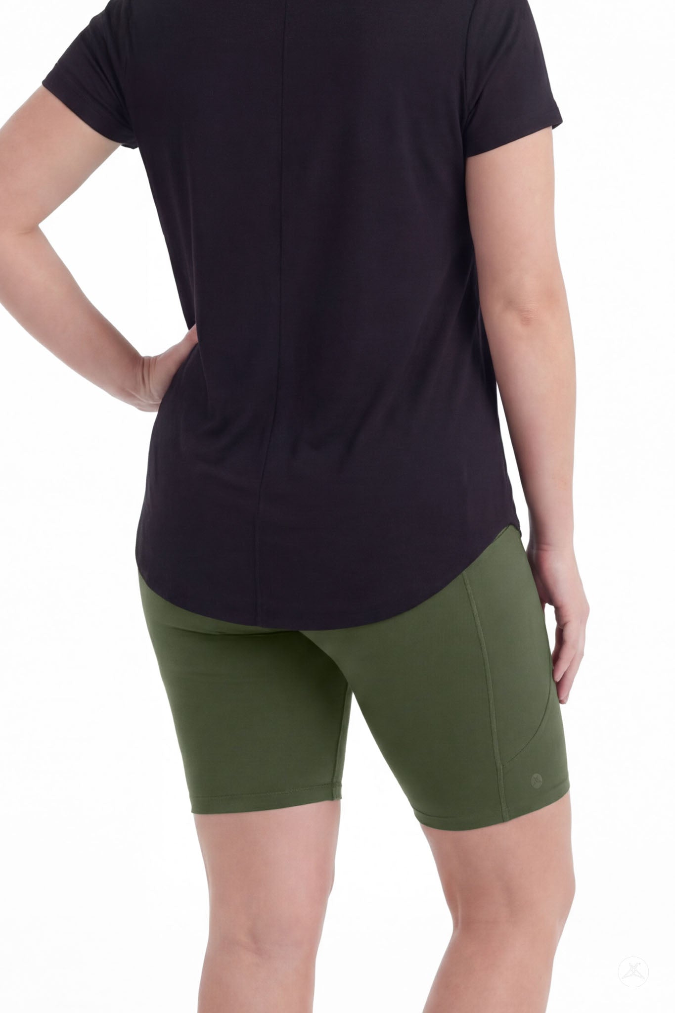 Woman wearing SweetLegs Cedar Pocket Biker Shorts in green with black top standing with hand on hip back view