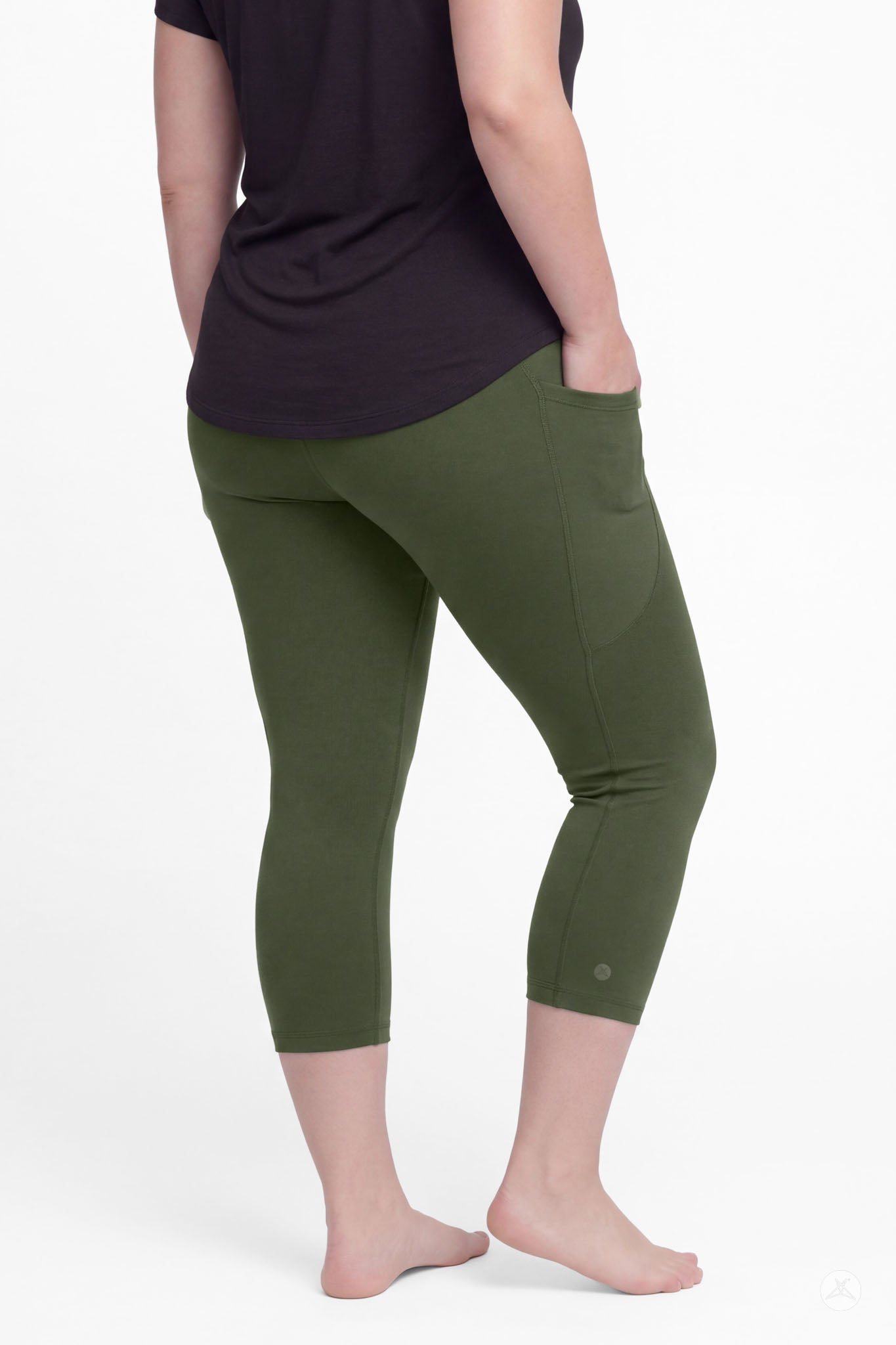 Back view of woman wearing SweetLegs Cedar Pocket Crops in olive green with side pockets and black top barefoot